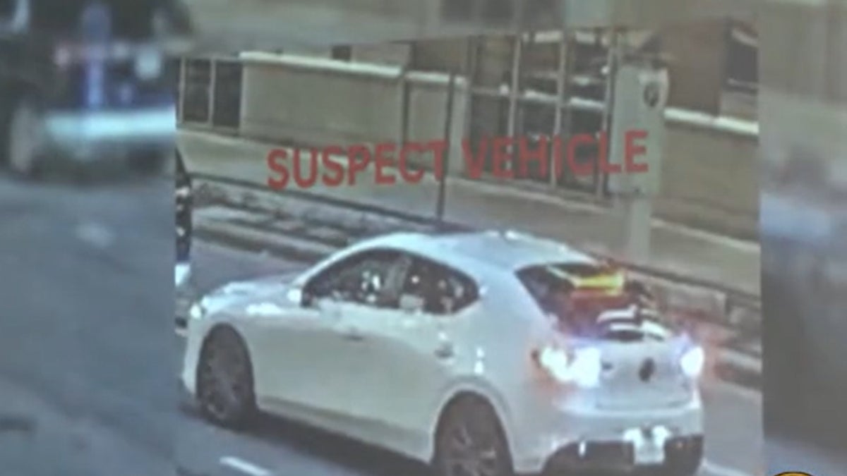 Suspects seen on surveillance camera driving away in a white Mazda