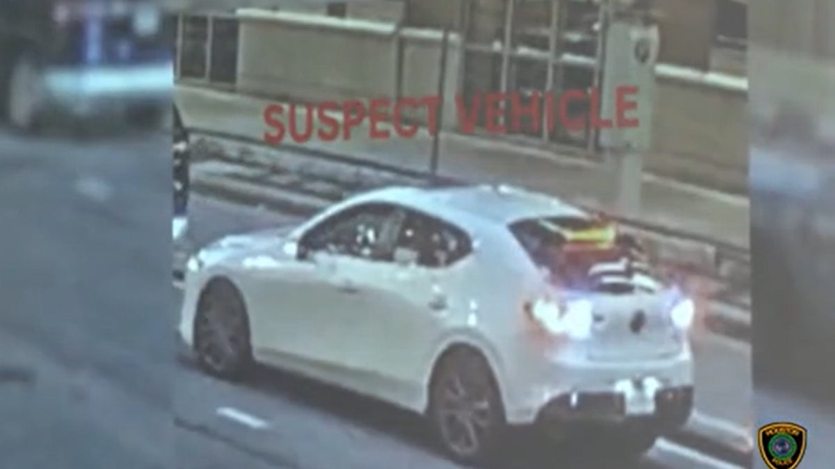 Suspects seen on surveillance camera driving away in a white Mazda