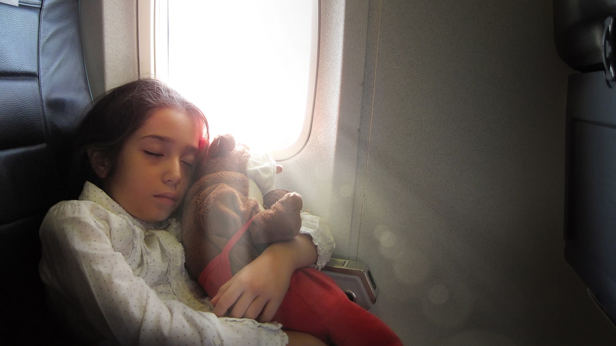 child sleeping on plane