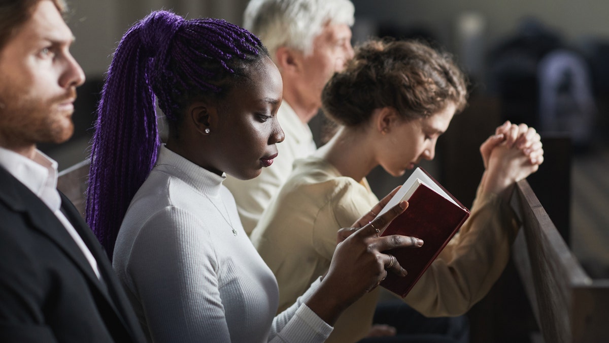 pessoas orando no banco da igreja