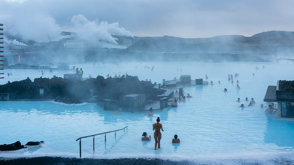 People stepping into Blue Lagoon in Iceland