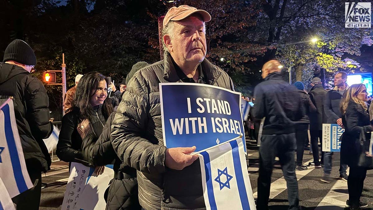 Hombre con gorra de béisbol sosteniendo un cartel pro-Israel