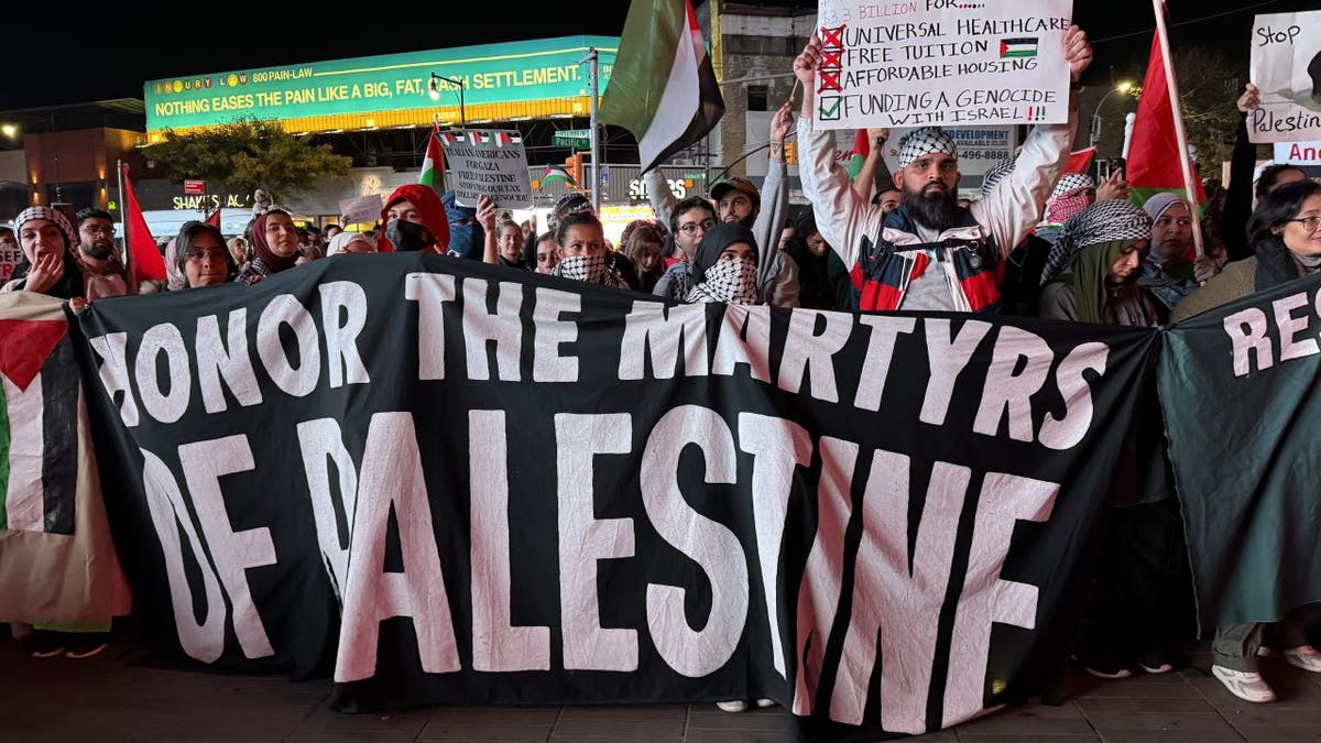 Protestors holding sign reading "Honor the martyrs of Palestine"