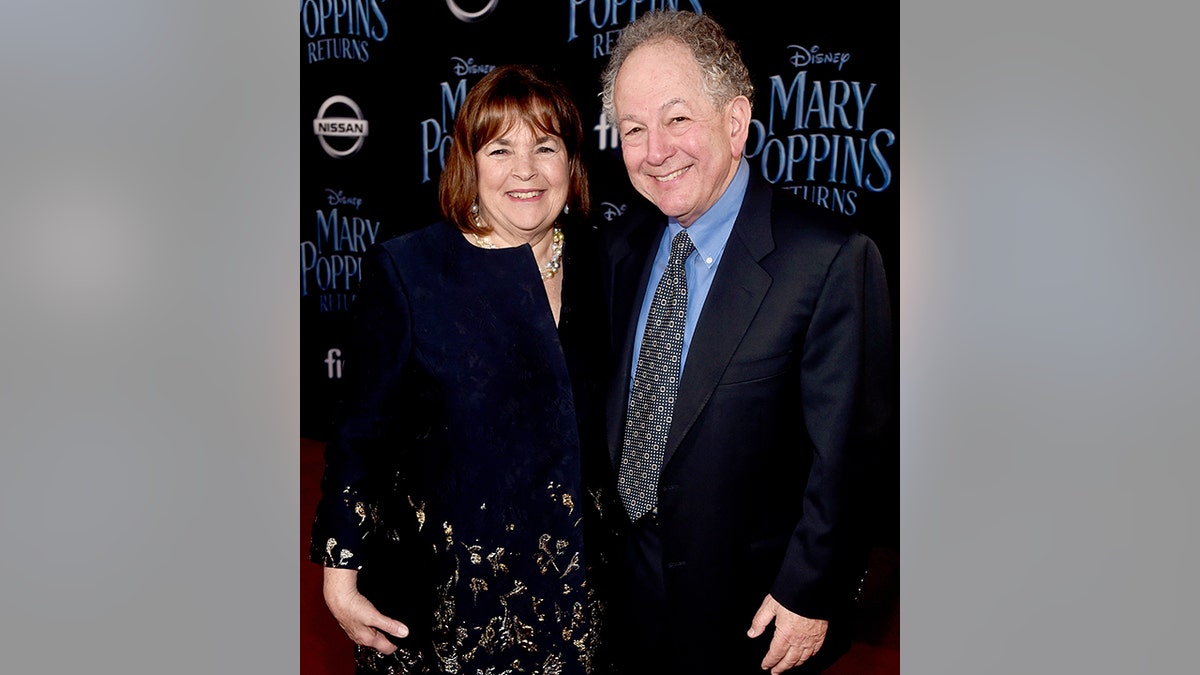 Ina and Jeffrey Garten pose on the carpet in a black dress and black suit at the "Mary Poppins Returns' world premiere