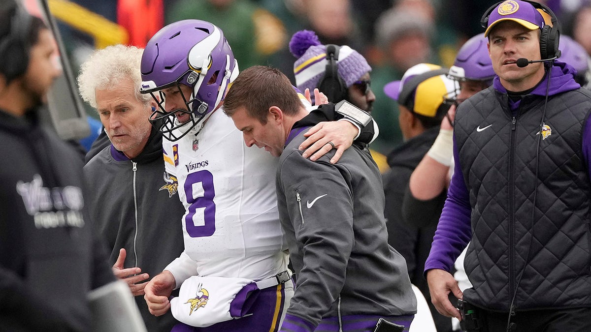 Kirk Cousins is helped off the football field