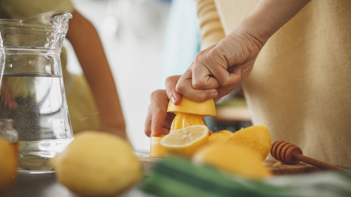 wanita sedang membuat jus lemon