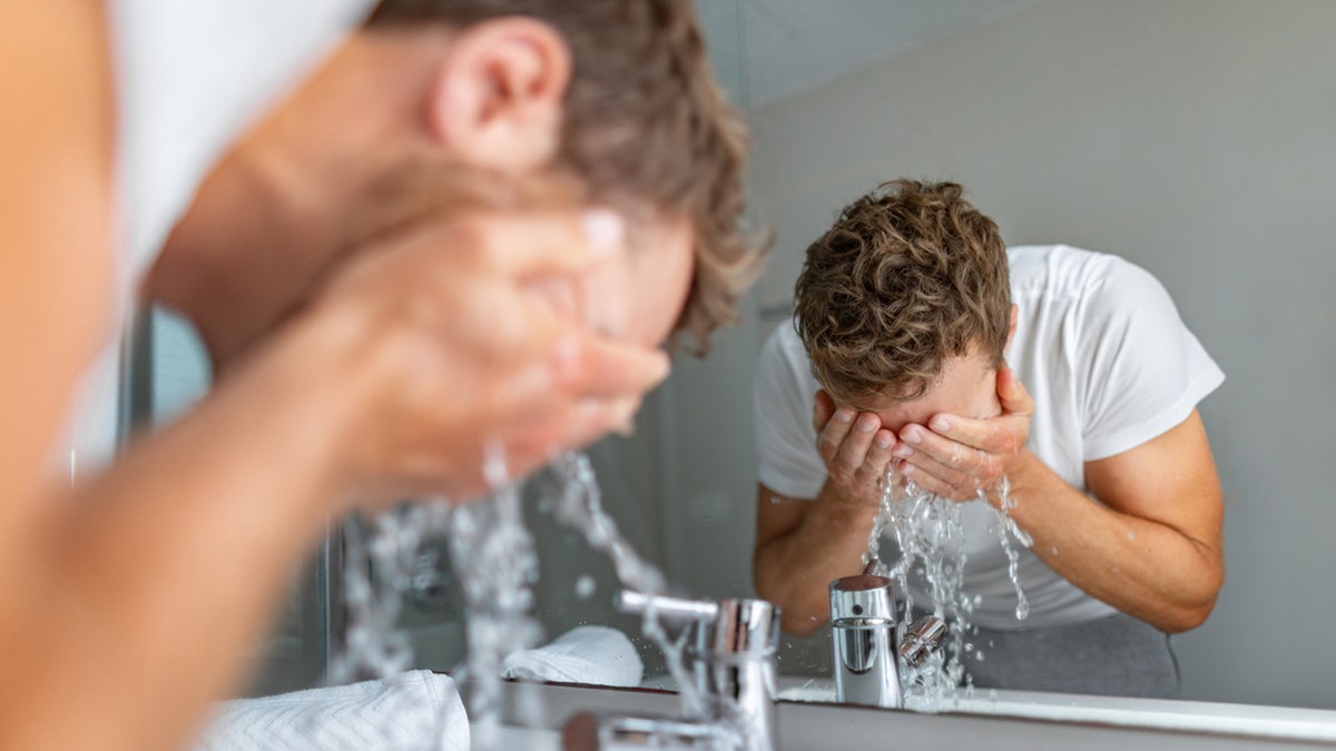 man rinsing face