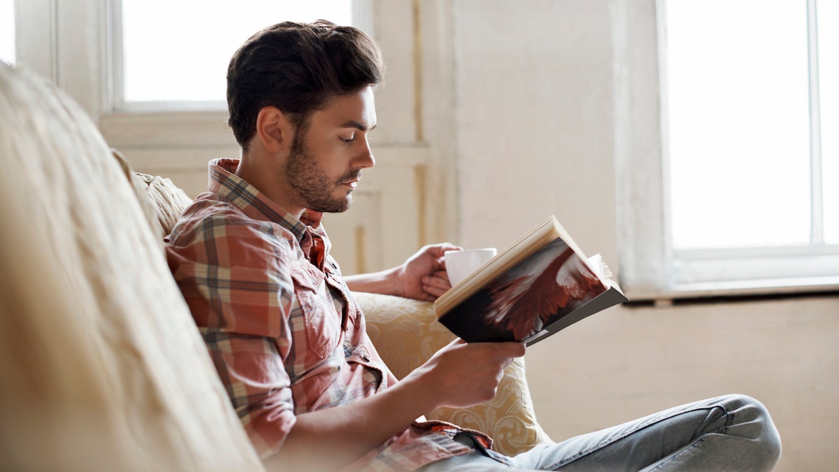 Man reading book on the couch