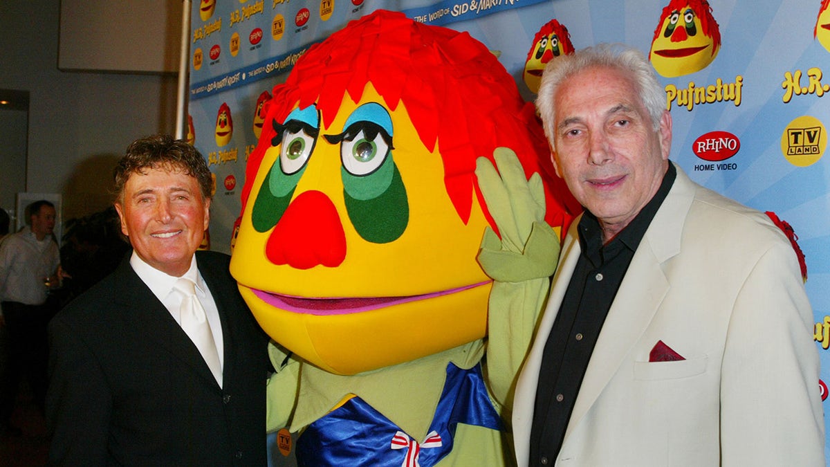 Marty Krofft and brother Sid pose by HR Pufnstuff character