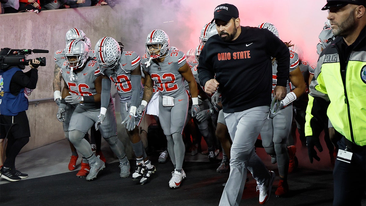 Ohio State coach Ryan Day leads his team onto the field