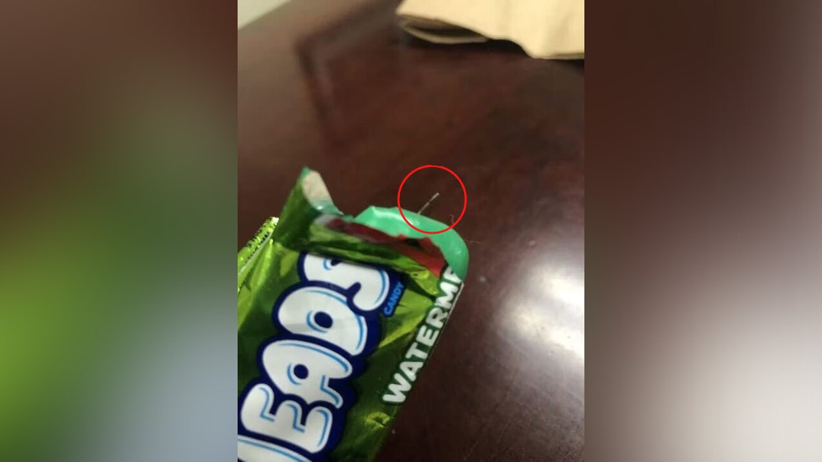 A needle sticking out of a watermelon flavored AirHead