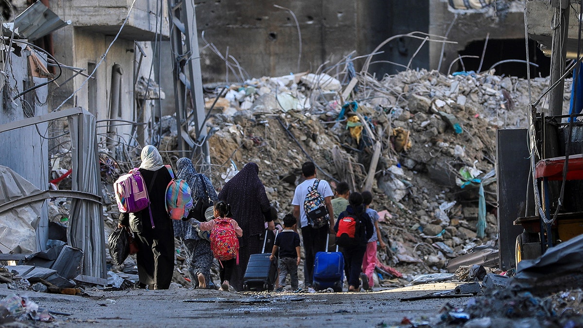 Palestinians carry their belongings as they flee their homes
