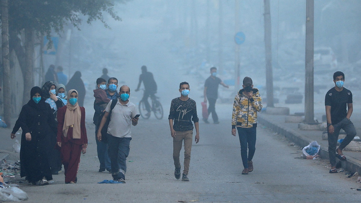 Palestinians walk amid fog in Gaza