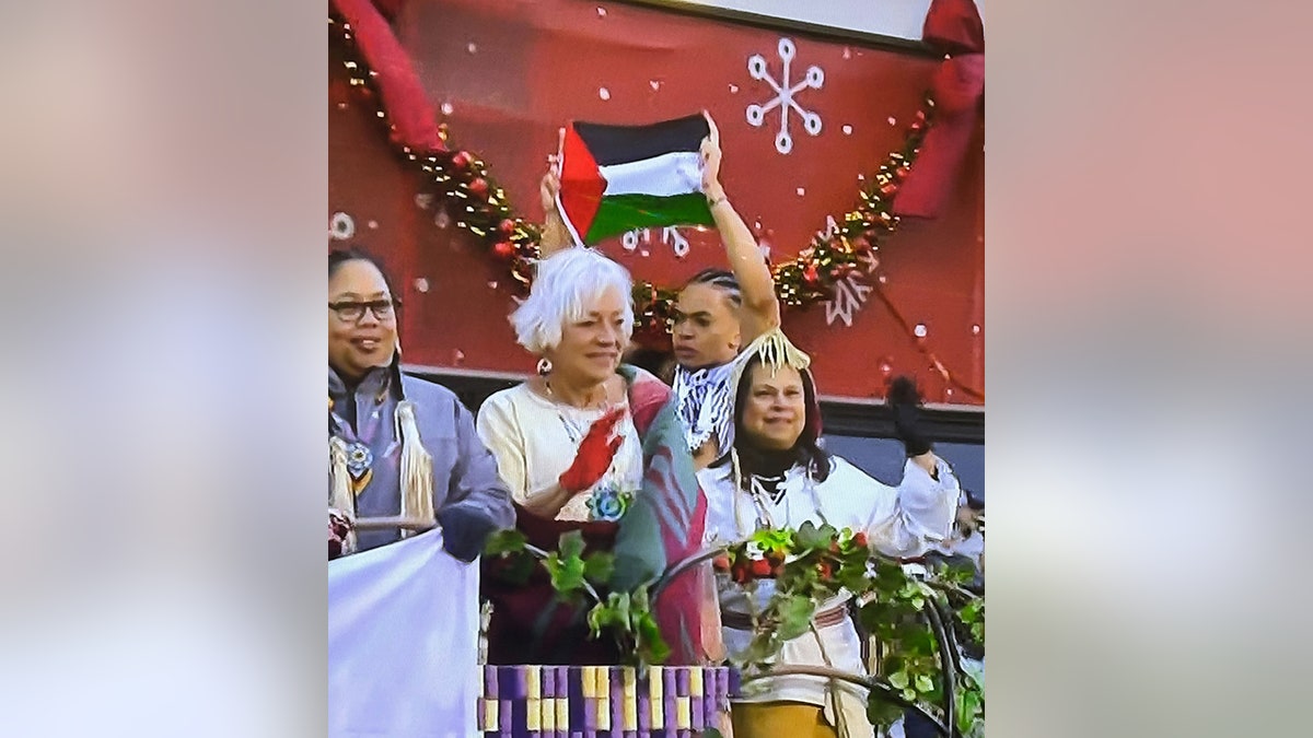 male holding Palestinian flag on float