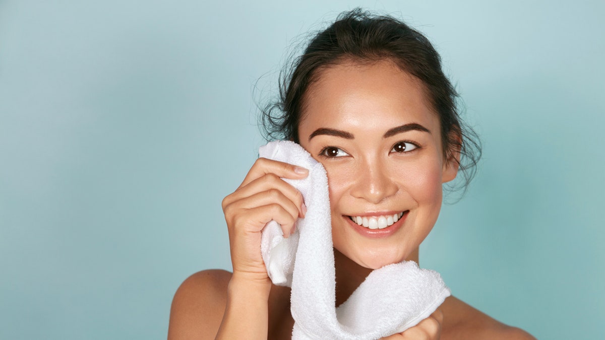 woman patting face dry