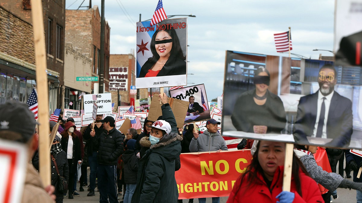 Protesters hold signs opposed to migrant camp in Brighton Park