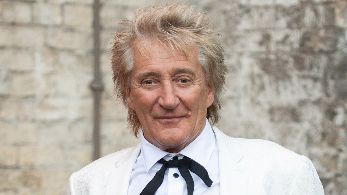 Rod Stewart sfoggia una cravatta elegante con un abito bianco