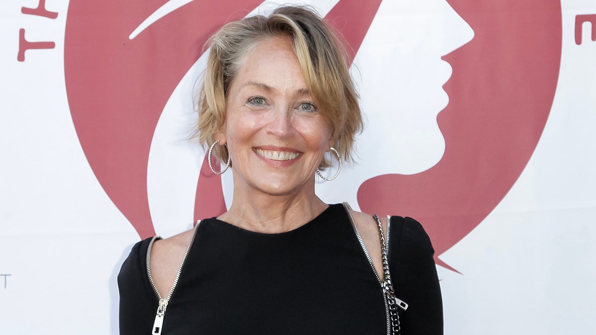 Sharon Stone in un abito nero con le spalle aperte sul tappeto