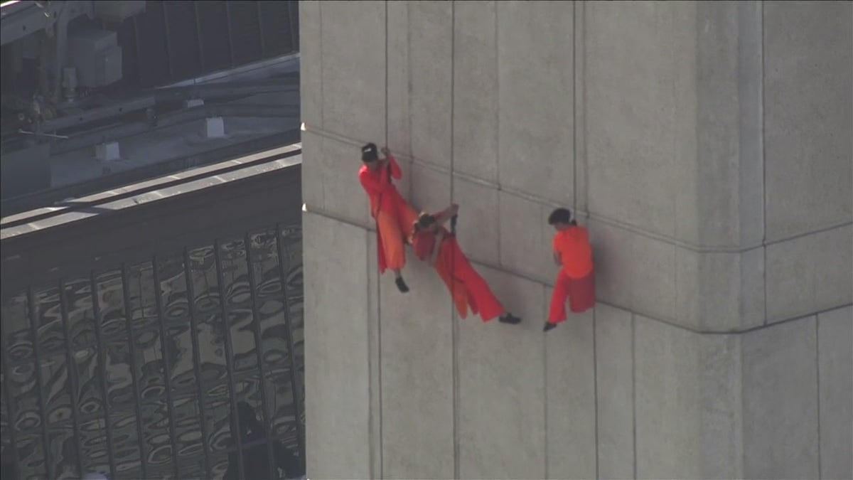 An Image of three performers on the side of the Transamerica Pyramid building in San Francisco 