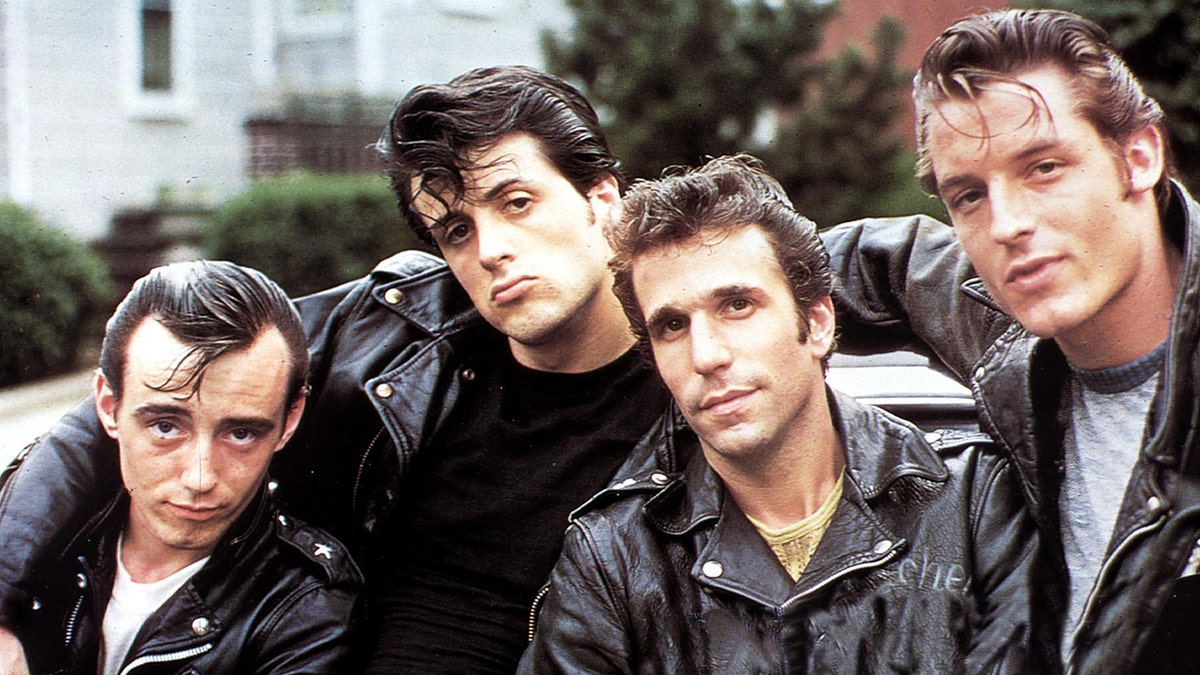 Perry King, Sylvester Stallone, Henry Winkler e Paul Mace Chico, todos sem jaquetas de couro, posam "Os Senhores de Flatbush"