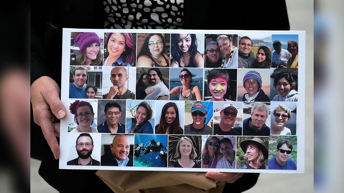 A woman holds a sign with images of the victims