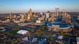 Aerial View of Charlotte, North Carolina on clear day showing highways and skyline and Bank of America Stadium.