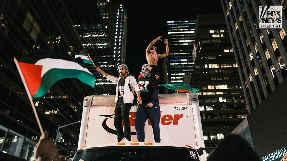 Pro-Palestine protesters atop a truck