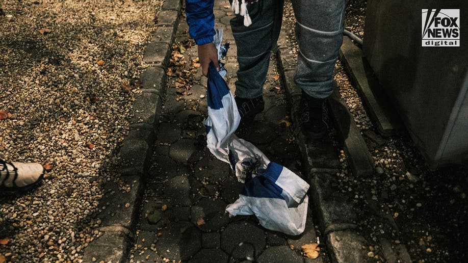 An Israeli flag is dragged on the ground after being set alight by a pro-Palestine protestor, New York