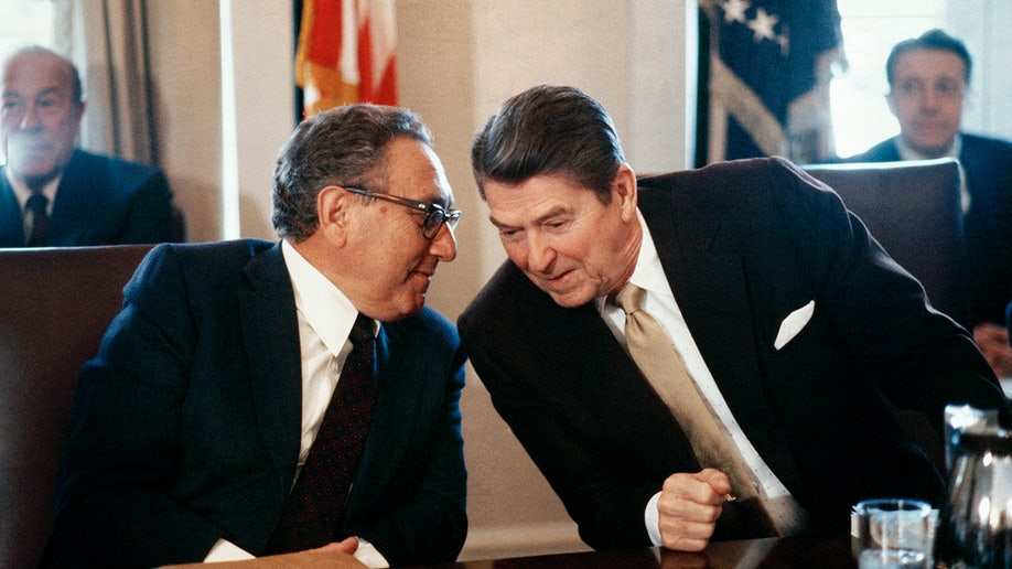 President Ronald Reagan and former Secretary of State Dr. Henry Kissinger whisper