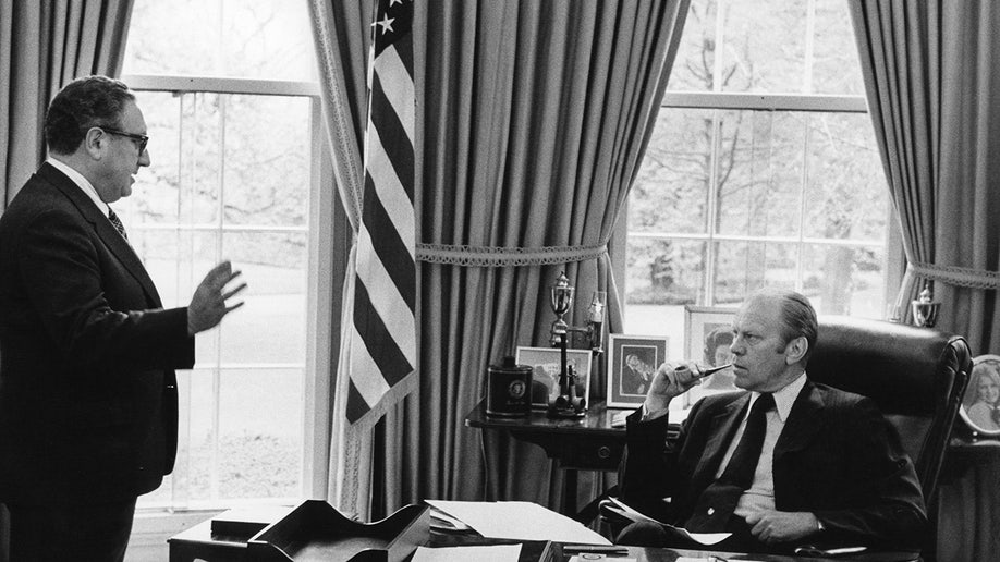 President Gerald R. Ford listens to Secretary Of State Henry Kissinger in the Oval Office