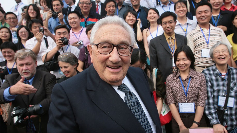 Henry Kissinger waits to attend a photo call