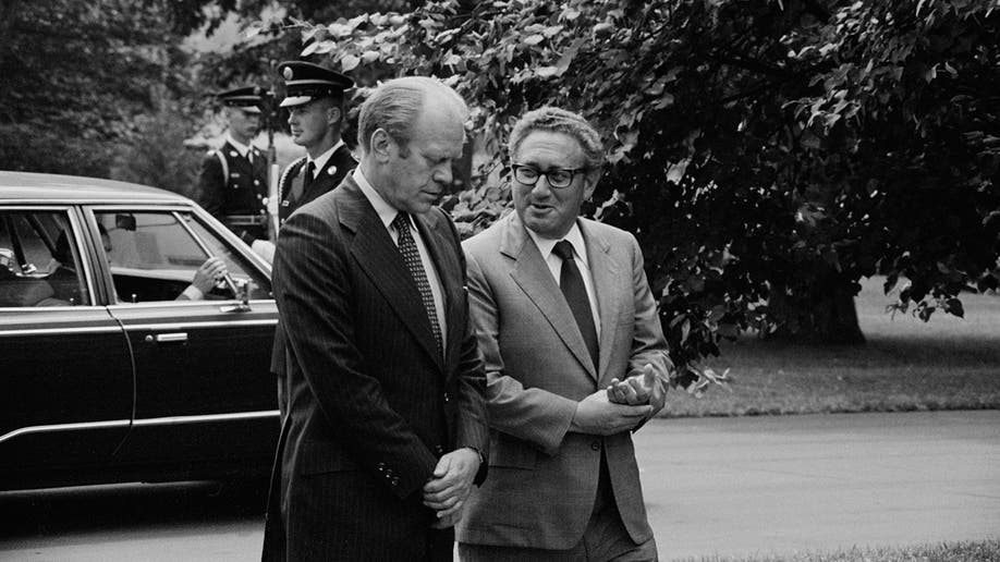 Gerald Ford and Henry Kissinger walk outside of the White House