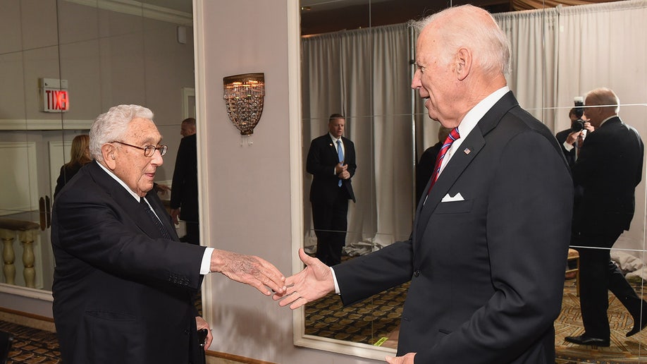 Joe Biden and Henry Kissinger shake hands