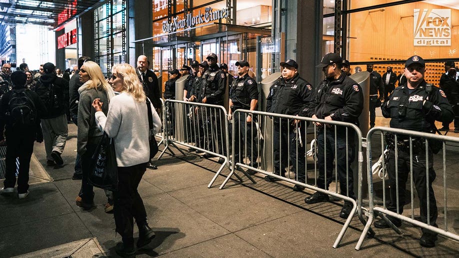 Police officers stand guard outside The New York Times’ headquarters as pro-Palestine protestors gather in midtown Manhattan