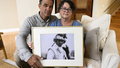 Derek and Suzi Alkonis pose with a photo of their son Lt. Ridge Alkonis in June 2022, in Dana Point, California.