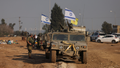 An Israeli soldier stands next to military vehicles near the Gaza Strip border on Monday, Dec. 18.