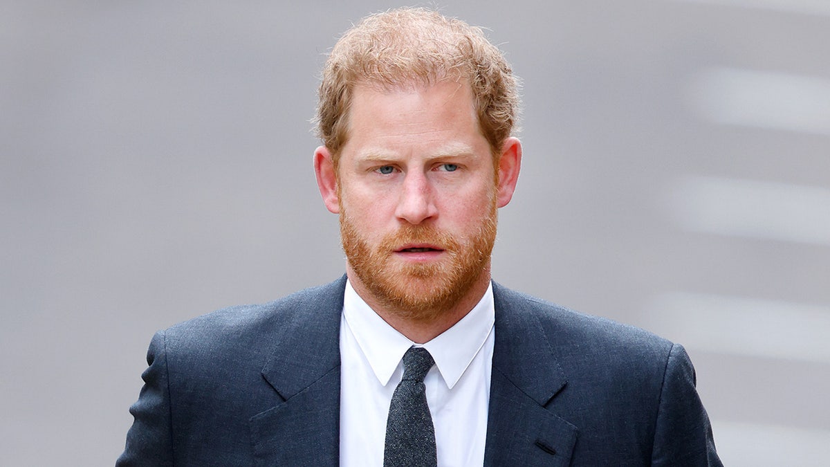 Um close do Príncipe Harry em terno e gravata azul-marinho
