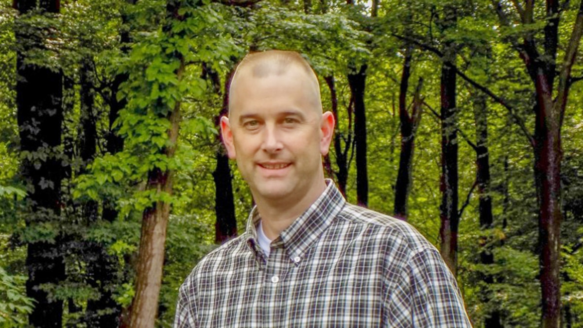 Kevin Miller standing near a forest