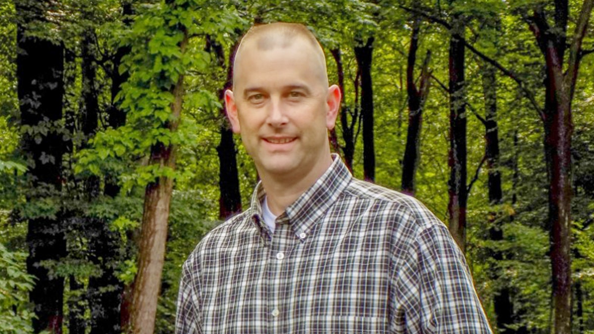 Kevin Miller standing near a forest