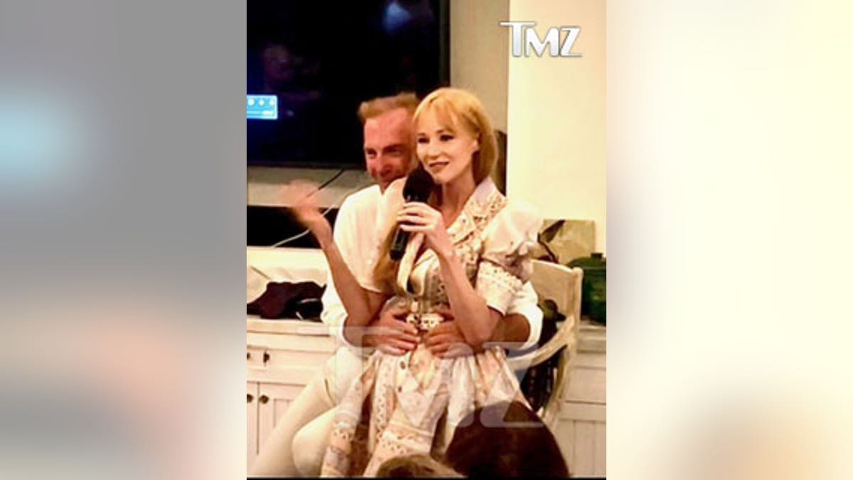 kevin costner holding jewel at charity event