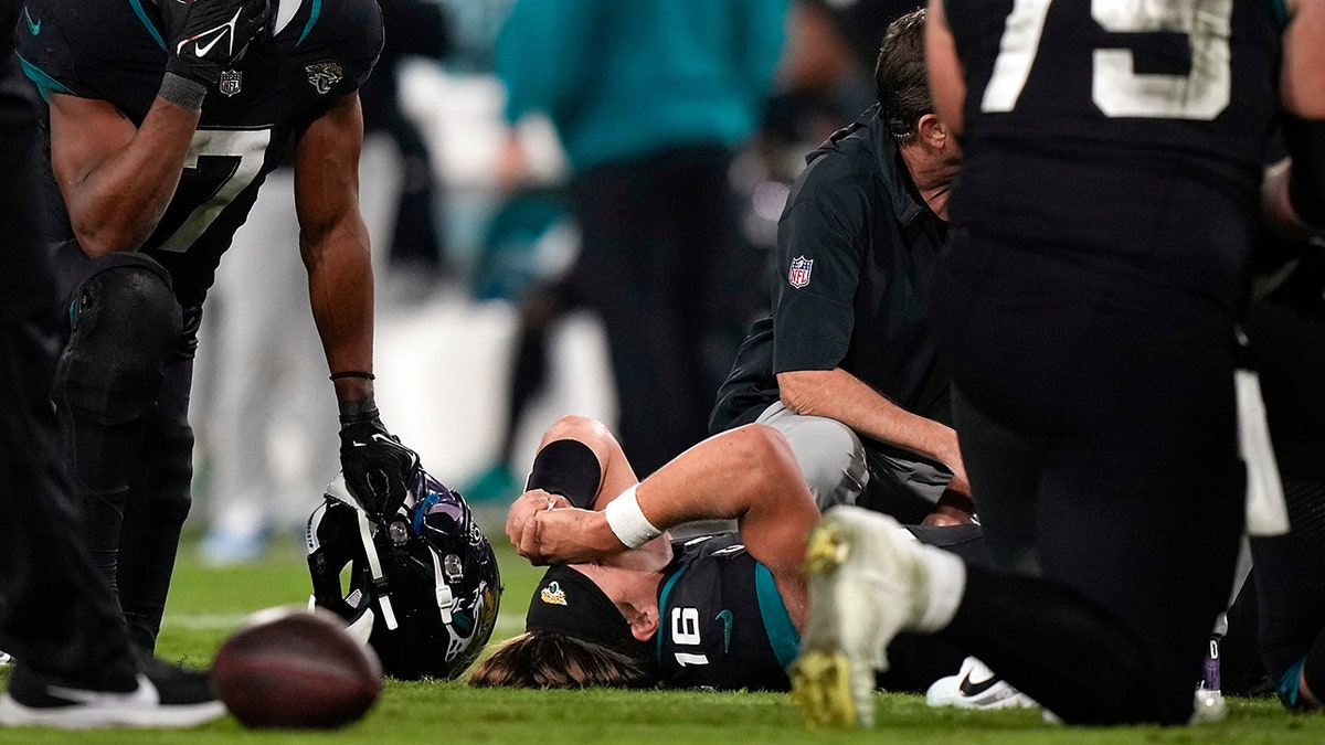 Trevor Lawrence’s wife, Marissa, shares kind messages from fans after QB’s ankle injury 1 Zay Jones prays near Trevor Lawrence