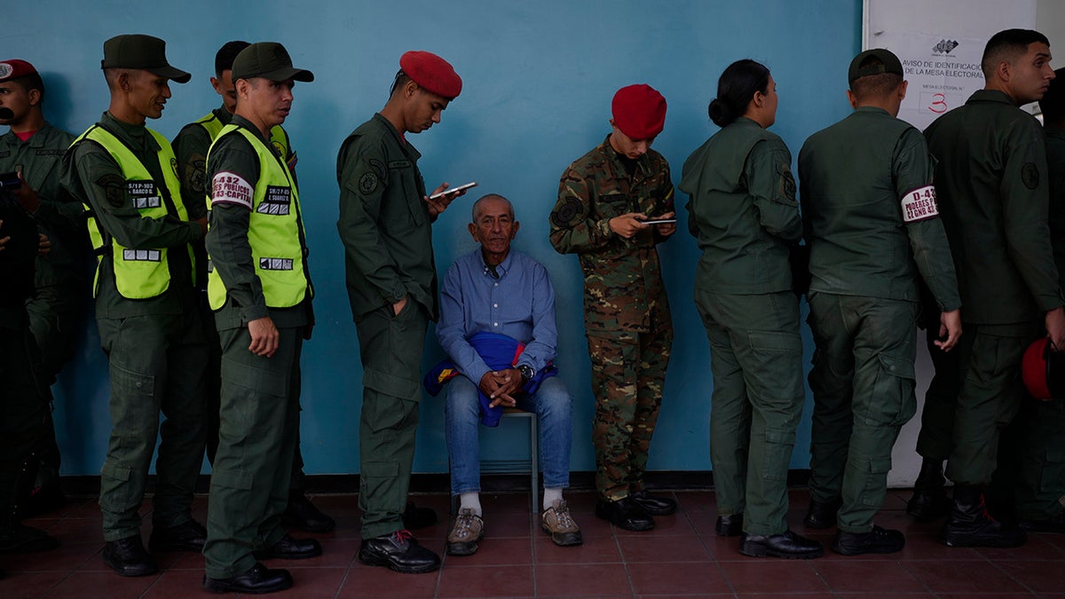 Soldiers and civilians wait in line to vote in Venezuela