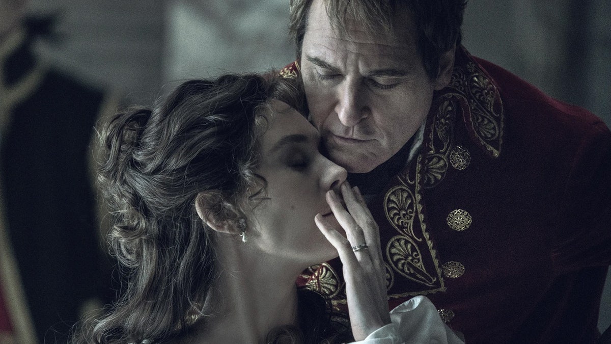 A dark close-up scene of Vanessa Kirby and Joaquin Phoenix from the film Napoleon