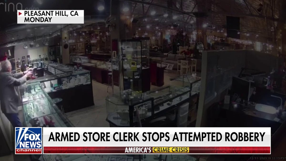 surveillance video of store clerk pointing gun at suspects
