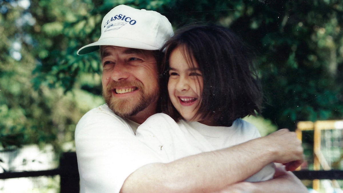 Thomas Randele dressed in white hugging his daughter Ashley who is also dressed in white