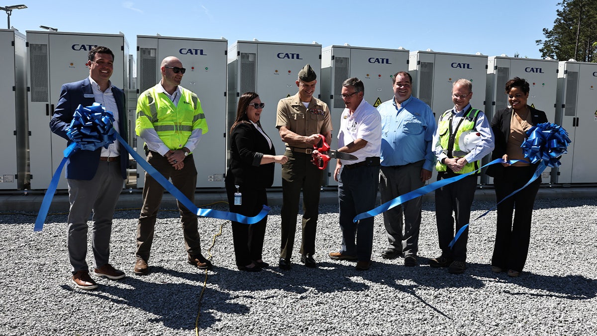 Battery Energy Storage System leaders and U.S. Marine Corps Brig. Gen. Andrew M. Niebel, commanding general of Marine Corps Installations East (MICEAST)-Marine Corps Base (MCB) Camp Lejeune (fourth from the left), cut a ribbon during the ribbon cutting ceremony on Marine Corps Base Camp Lejeune, North Carolina, April 13, 2023. Duke Energy is hosting the largest battery system in North Carolina and will frequently be operated in conjunction with the adjacent solar facility located on base, therefore strengthening the overall reliability of the energy grid and supporting the transition to cleaner energy.