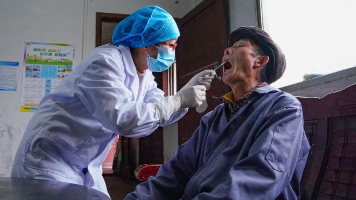 A medical worker swabs an elderly man in Chine 
