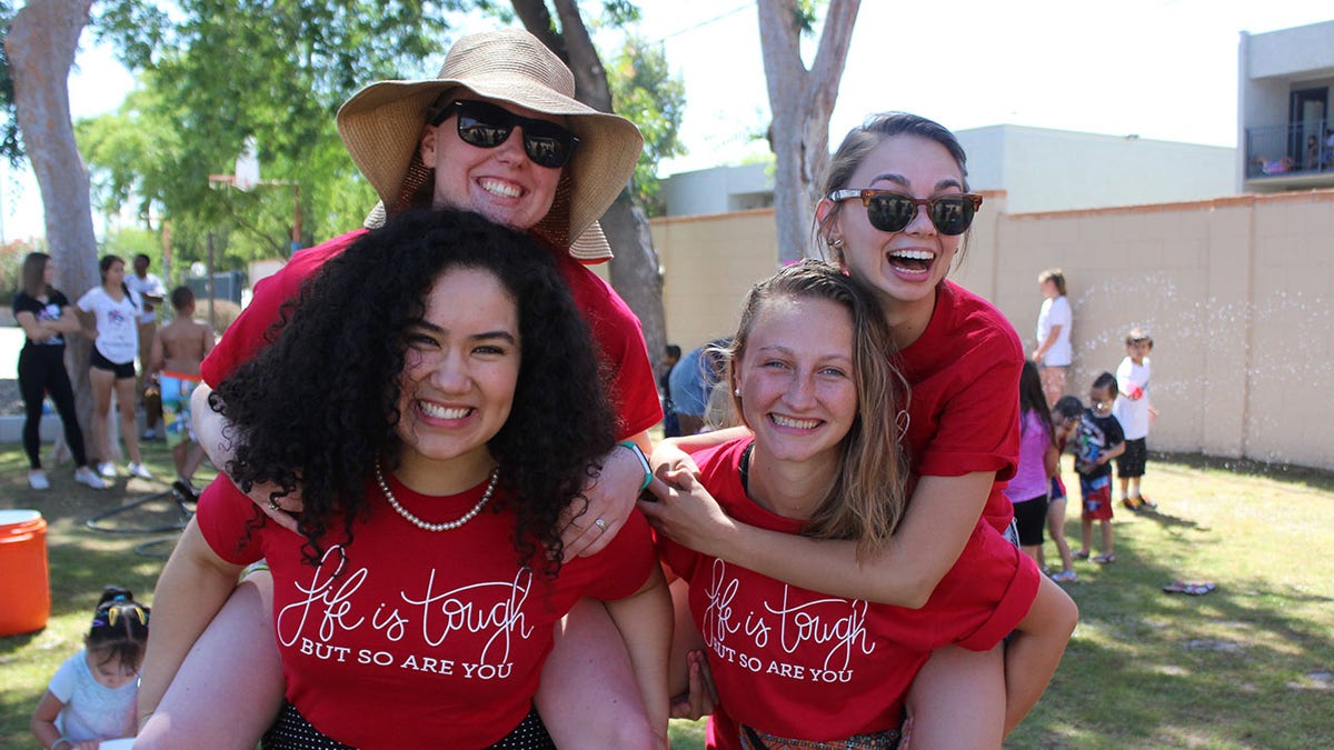 four young women in matching red shirts