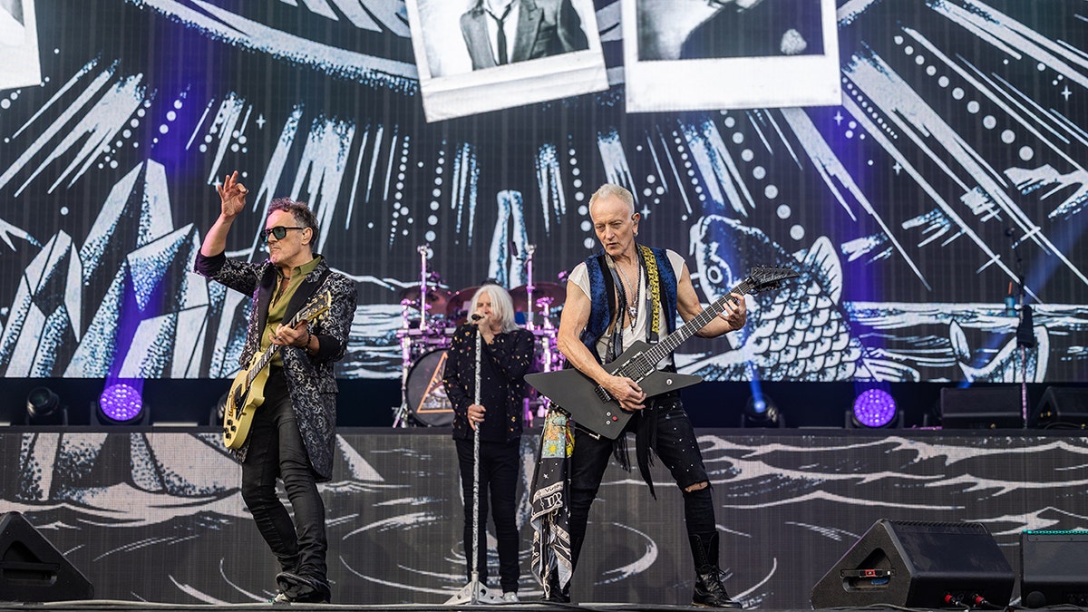 Vivian Campbell, Joe Elliott y Phil Collen de Def Leppard actúan en el escenario