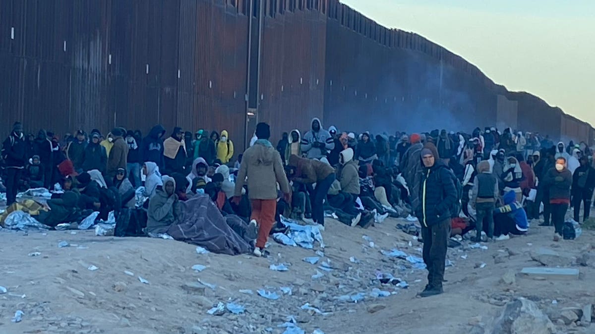 Migrants line up at border wall
